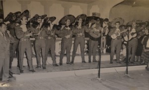 Yvonne Siqueiros, roughly age 8, seen through the legs of one of Pedro Infante's mariachis as she waits for her favorite star of the Mexican cinema to arrive.