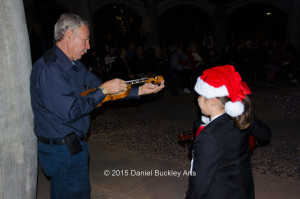 Alfredo Valenzuela, aka Dr. V, tunes violins at a Christmas performance by Mariachi Las Aguilitas de Davis Elementary at the University of Arizona.